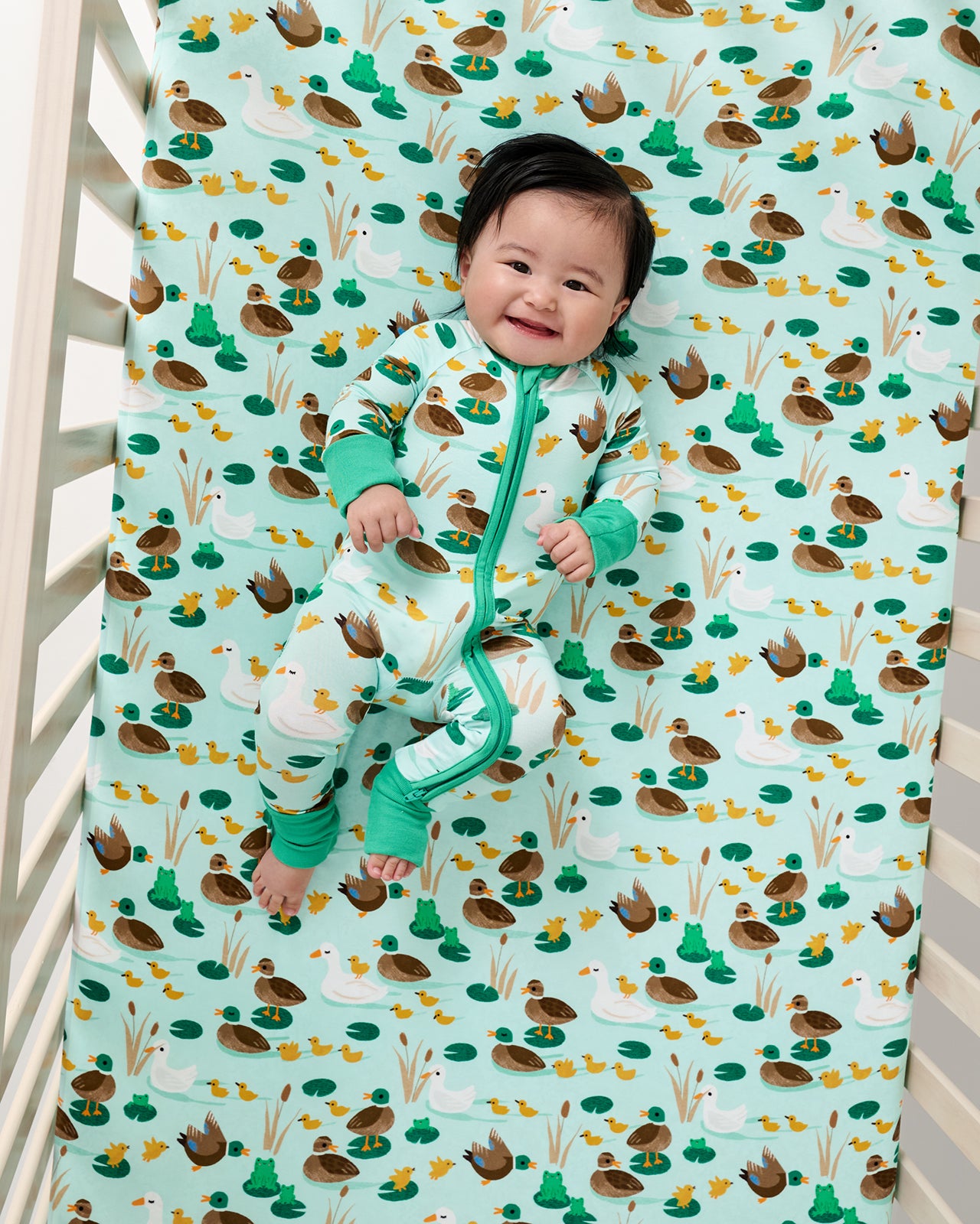 Aerial view of baby laying on the Puddle Jumpers Fitted Crib Sheet