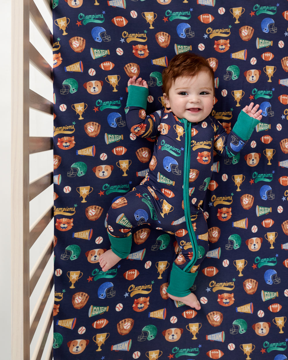 Overhead view of baby laying on the Team Spirit Fitted Crib Sheet
