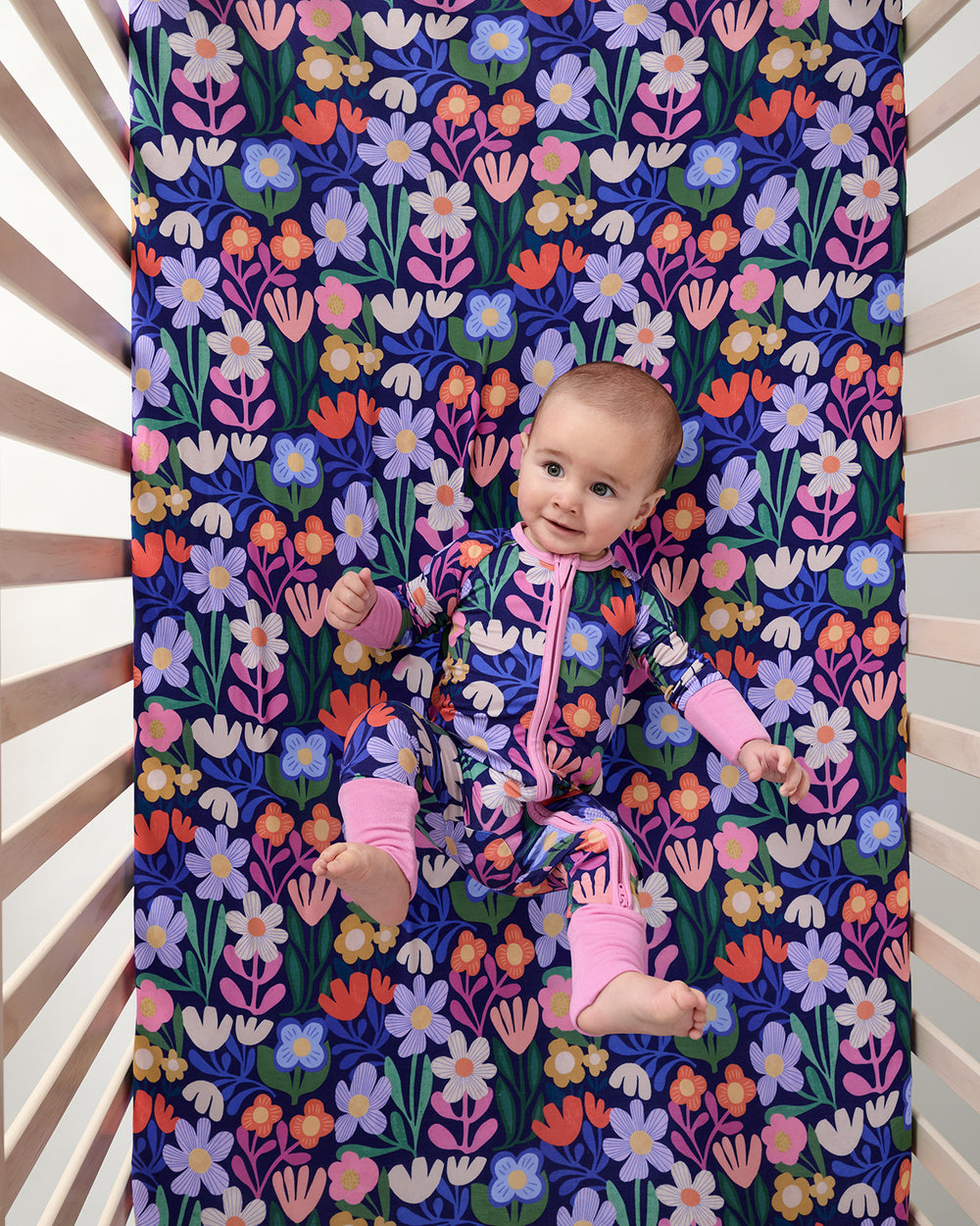 Aerial view of baby laying on the Wild Garden Fitted Crib Sheet