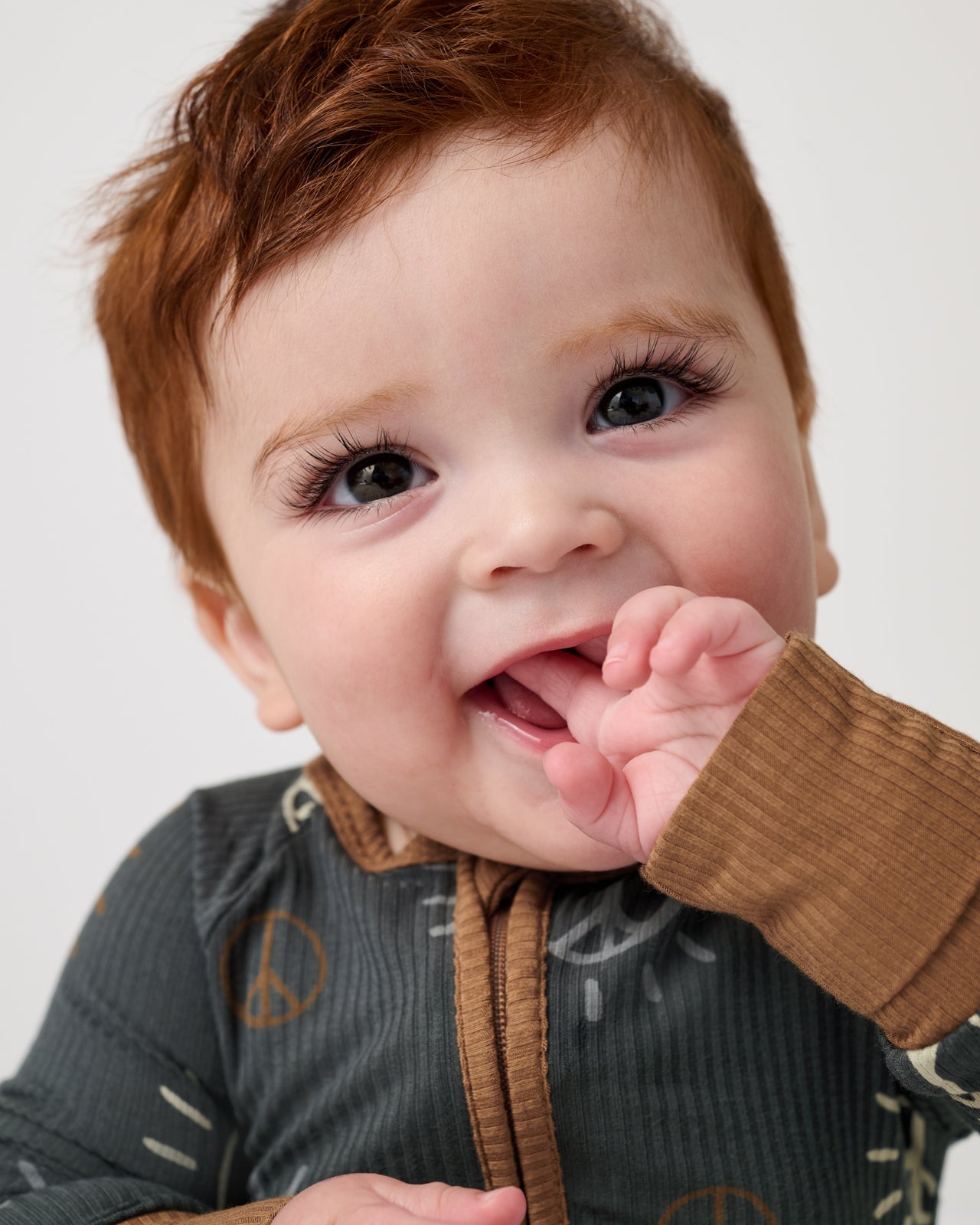 Close up of baby wearing the Peace & Love Ribbed Zippy
