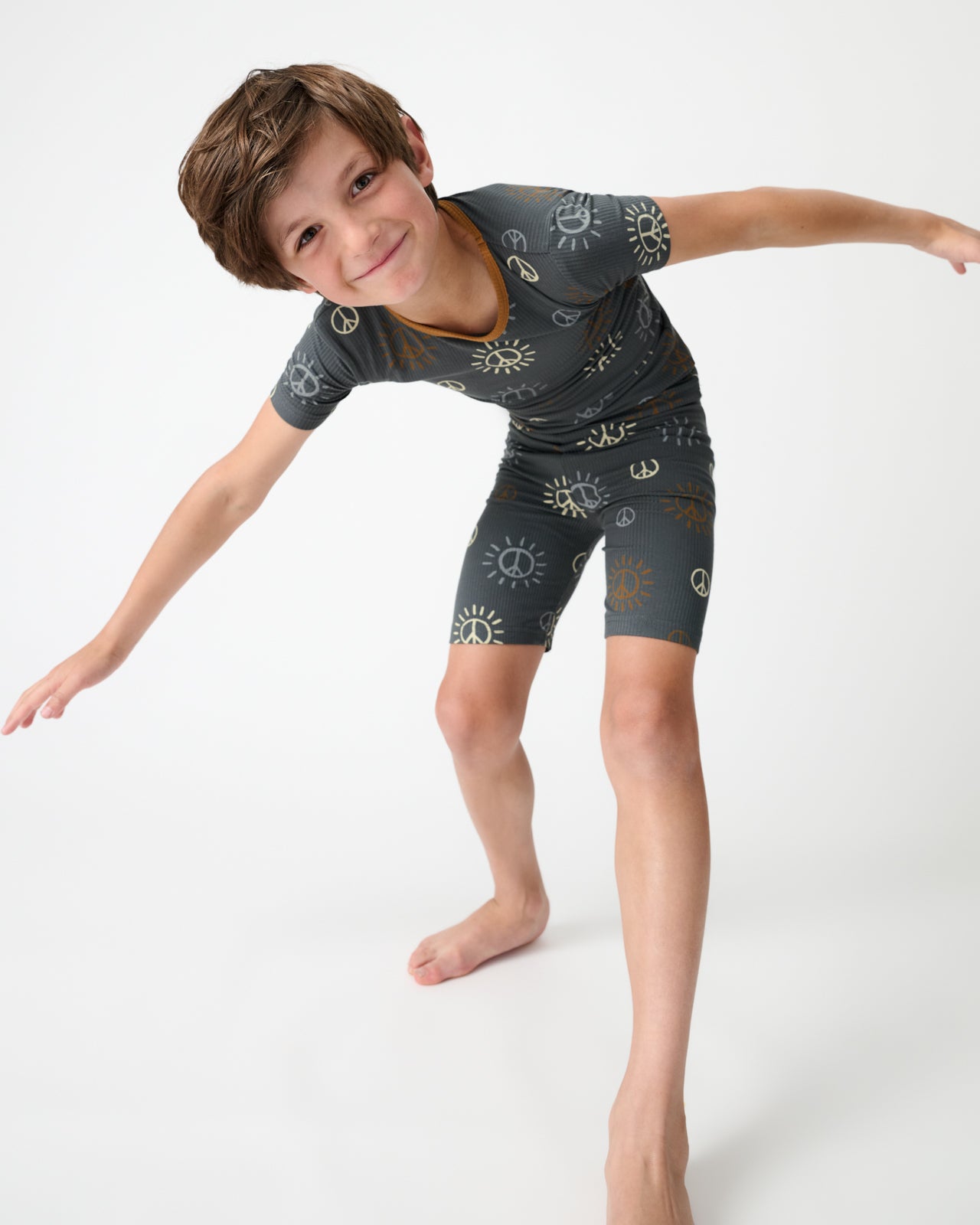 Posing child wearing the Peace & Love Ribbed Two-Piece Short Sleeve & Shorts Pajama Set