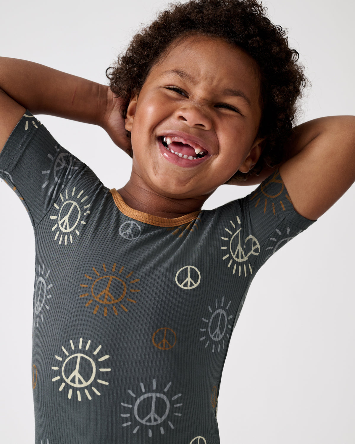 Close up of boy wearing the Peace & Love Ribbed Two-Piece Short Sleeve & Shorts Pajama Set