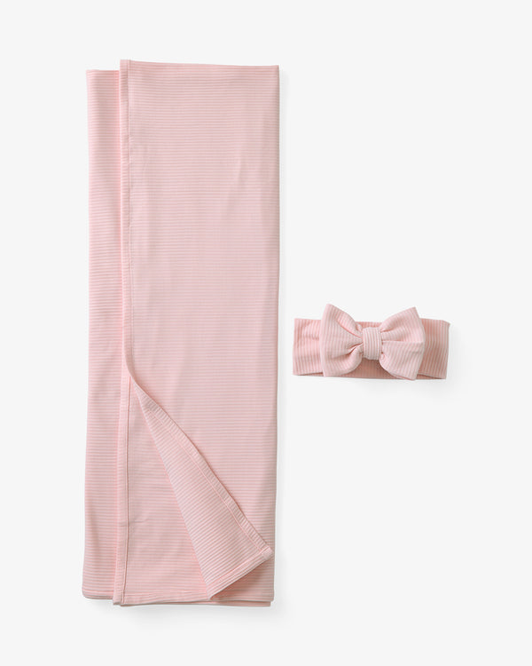 Flat lay of the Prima Pink Ribbed Swaddle & Luxe Bow Headband Set