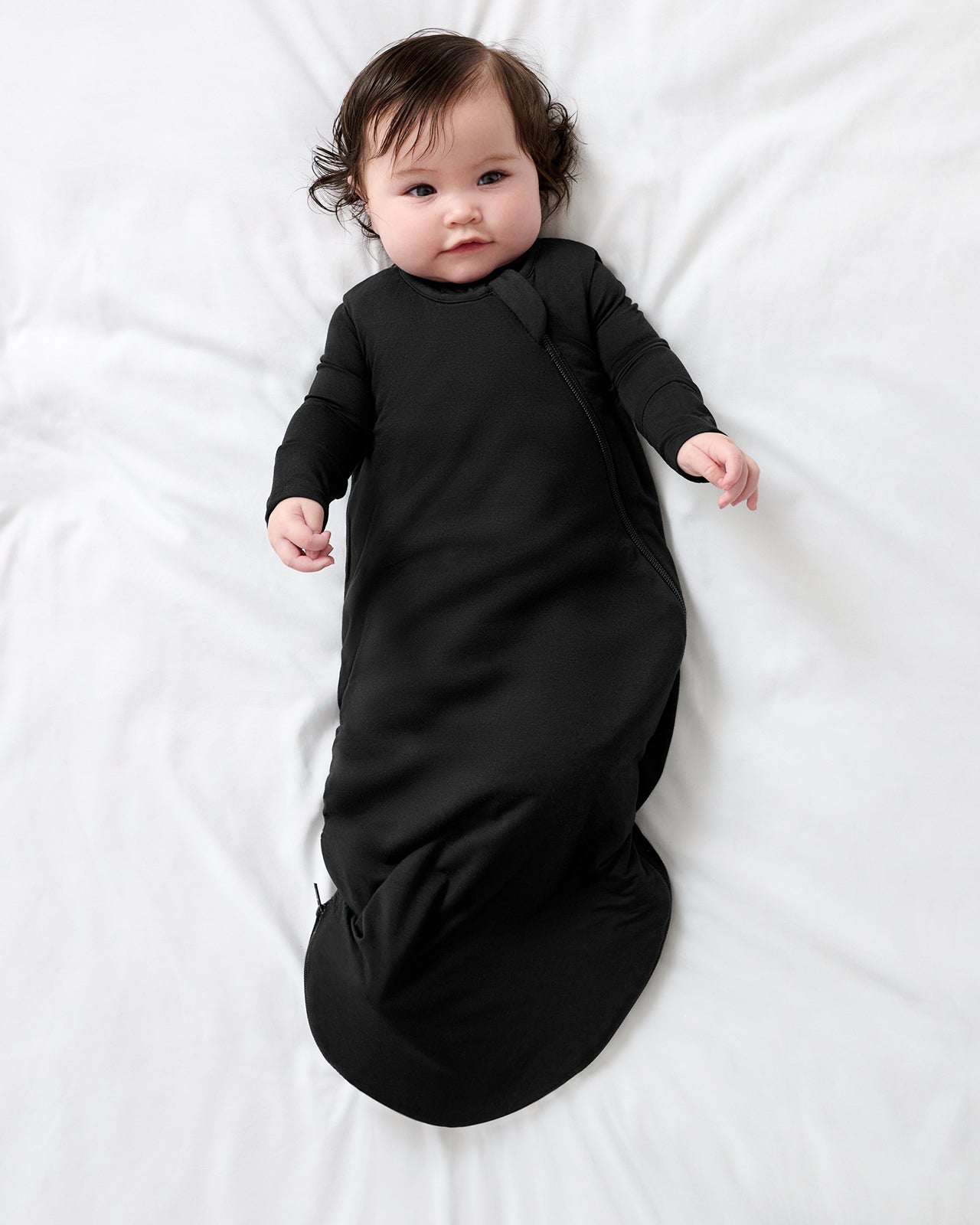Aerial view of baby wearing the Black Sleepy Bag wearing a black bodysuit