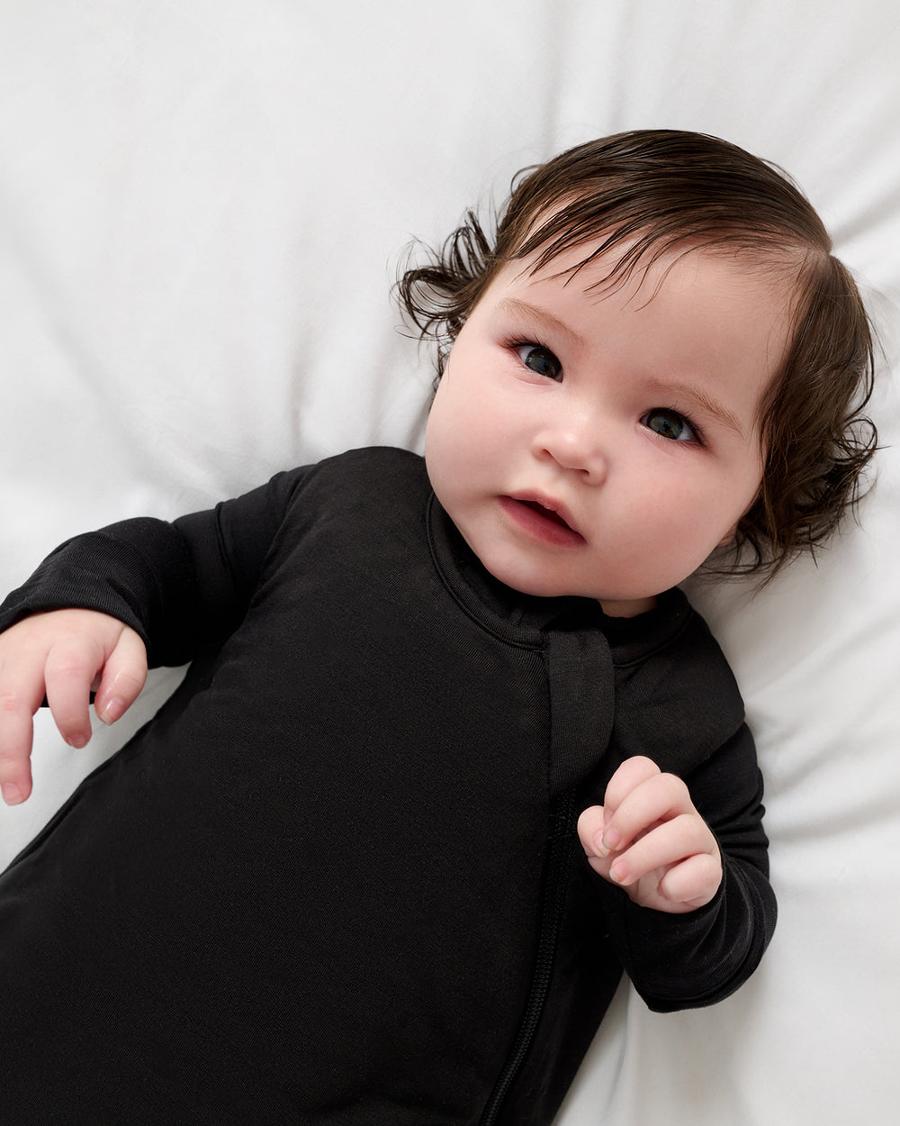 Close up of baby wearing the Black Sleepy Bag over a long sleeve black bodysuit