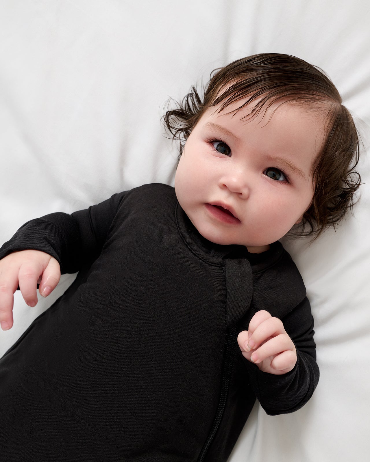 Close up of baby wearing the Black Sleepy Bag over a long sleeve black bodysuit