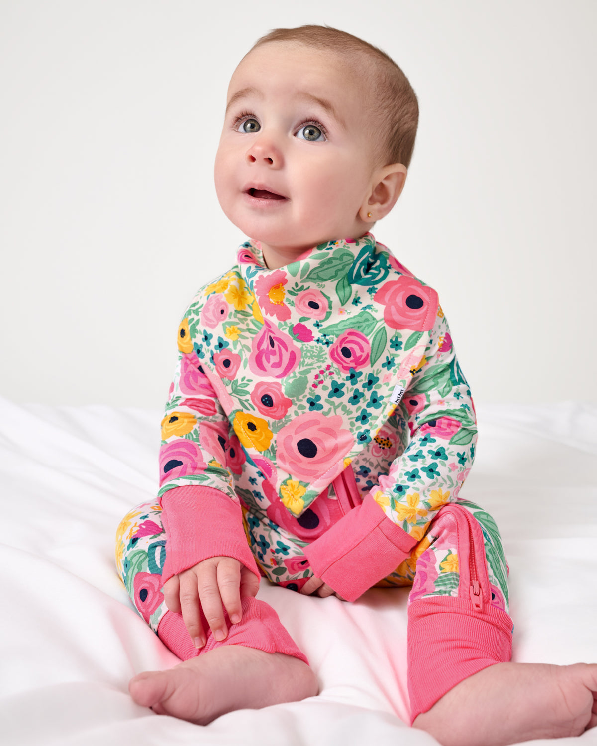 Sitting baby wearing the Secret Garden Bandana Bib