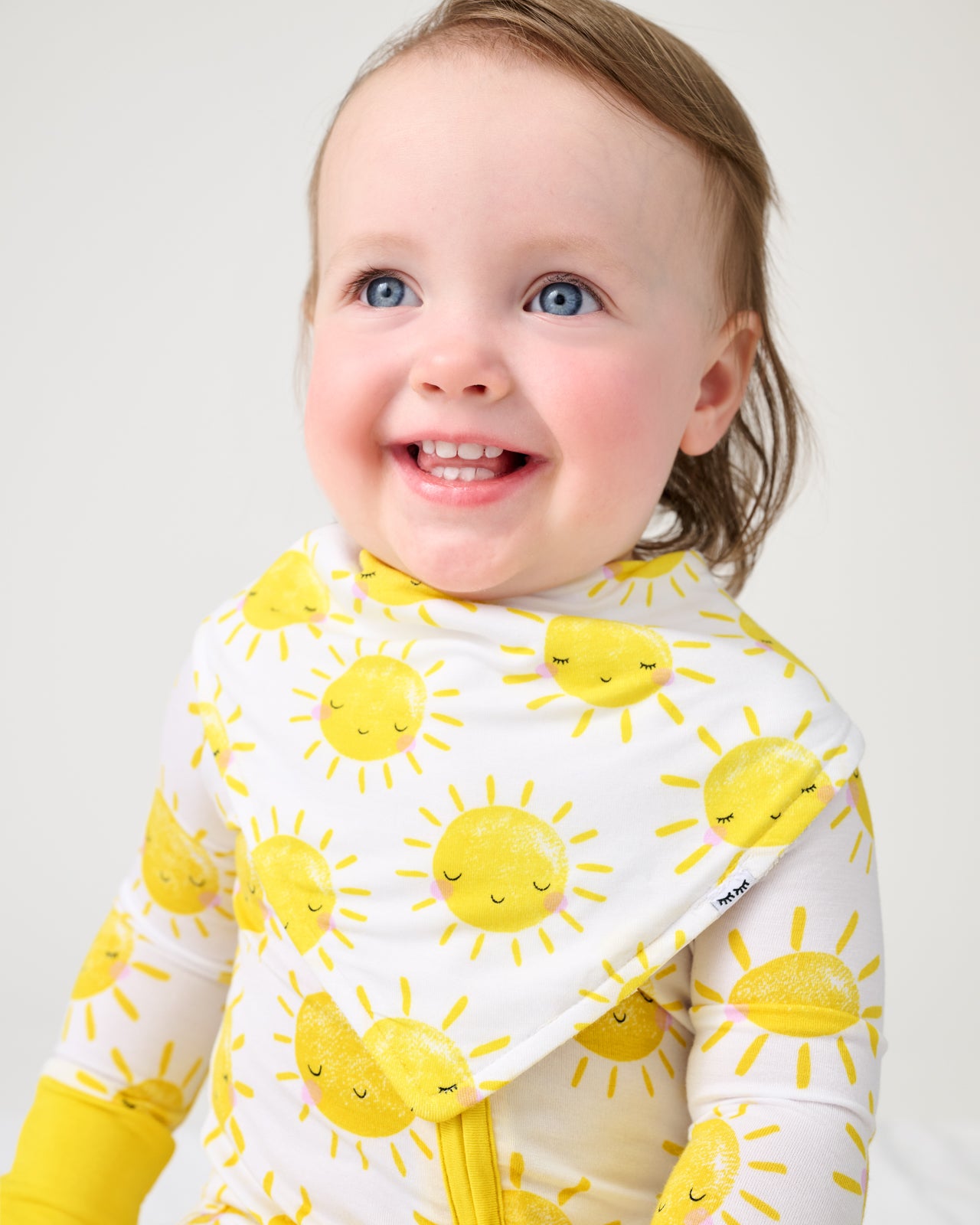 Baby wearing the Sunshine Bandana Bib