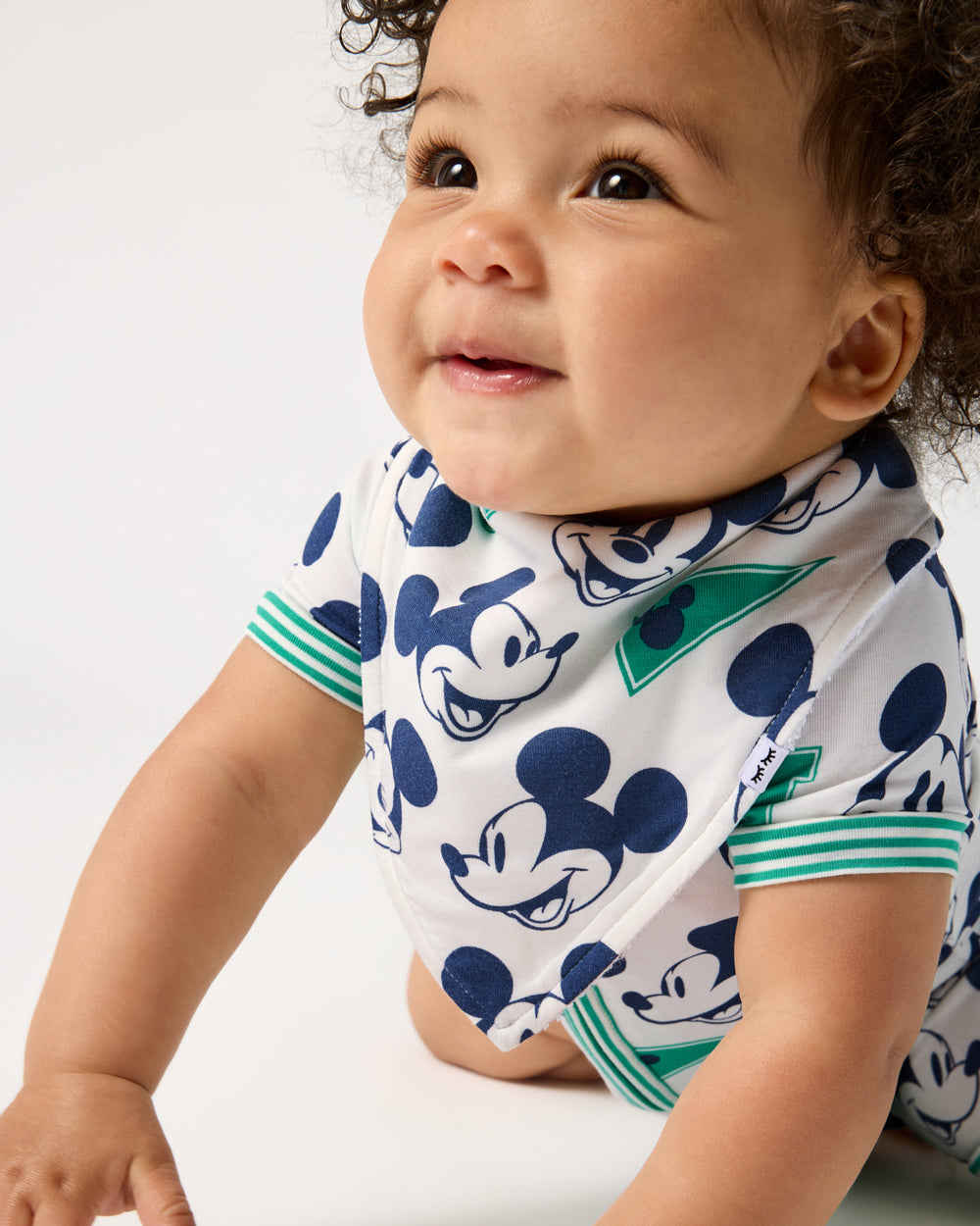 Close up of baby wearing the Disney Varsity Mickey Mouse Bandana Bib