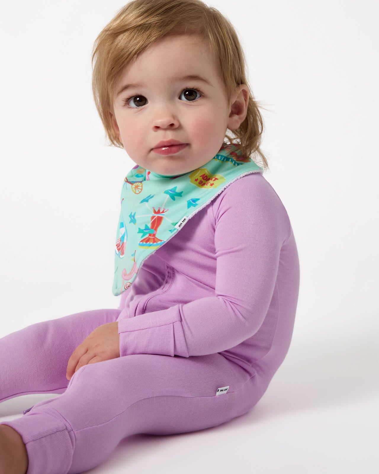 Baby wearing the Fizzy Fair Bandana Bib with the Soft Wisteria Zippy