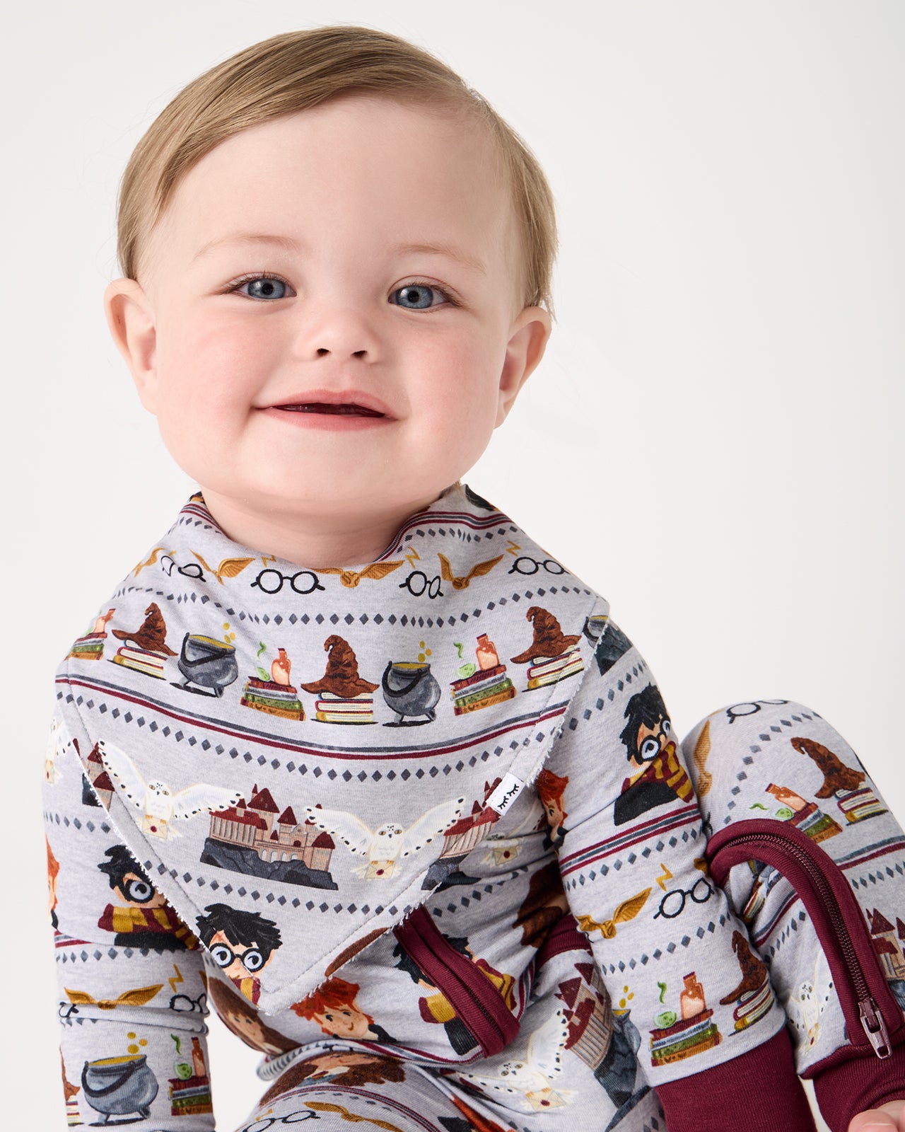 Baby wearing the Harry Potter™ Spellbinding Studies Bandana Bib