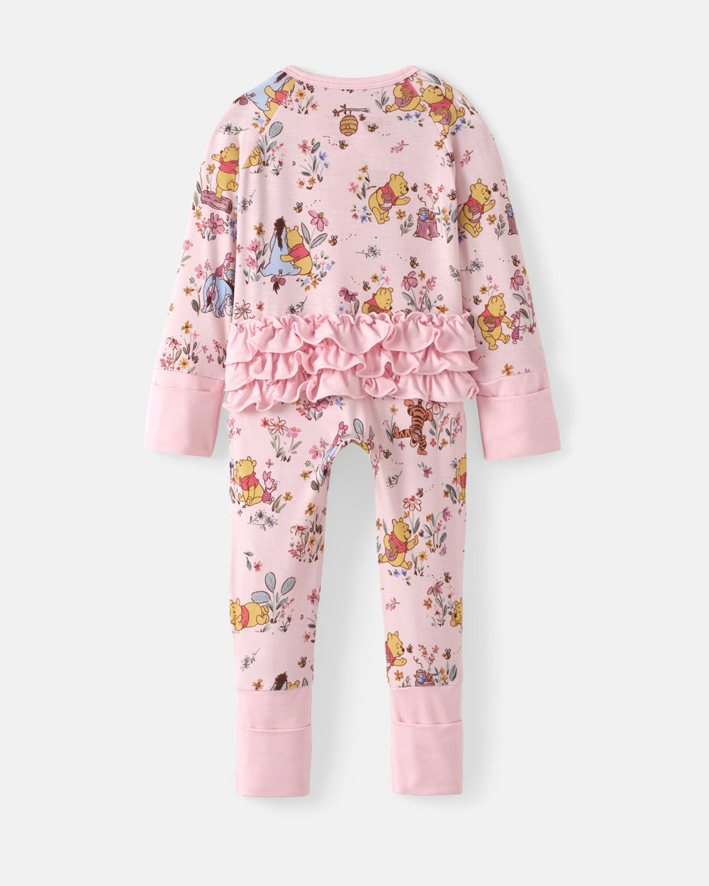 A children's long-sleeve pajama set in light pink, featuring an all-over Winnie the Pooh and Disney princess print, a ruffled waist detail, and solid pink cuffs and hem.
