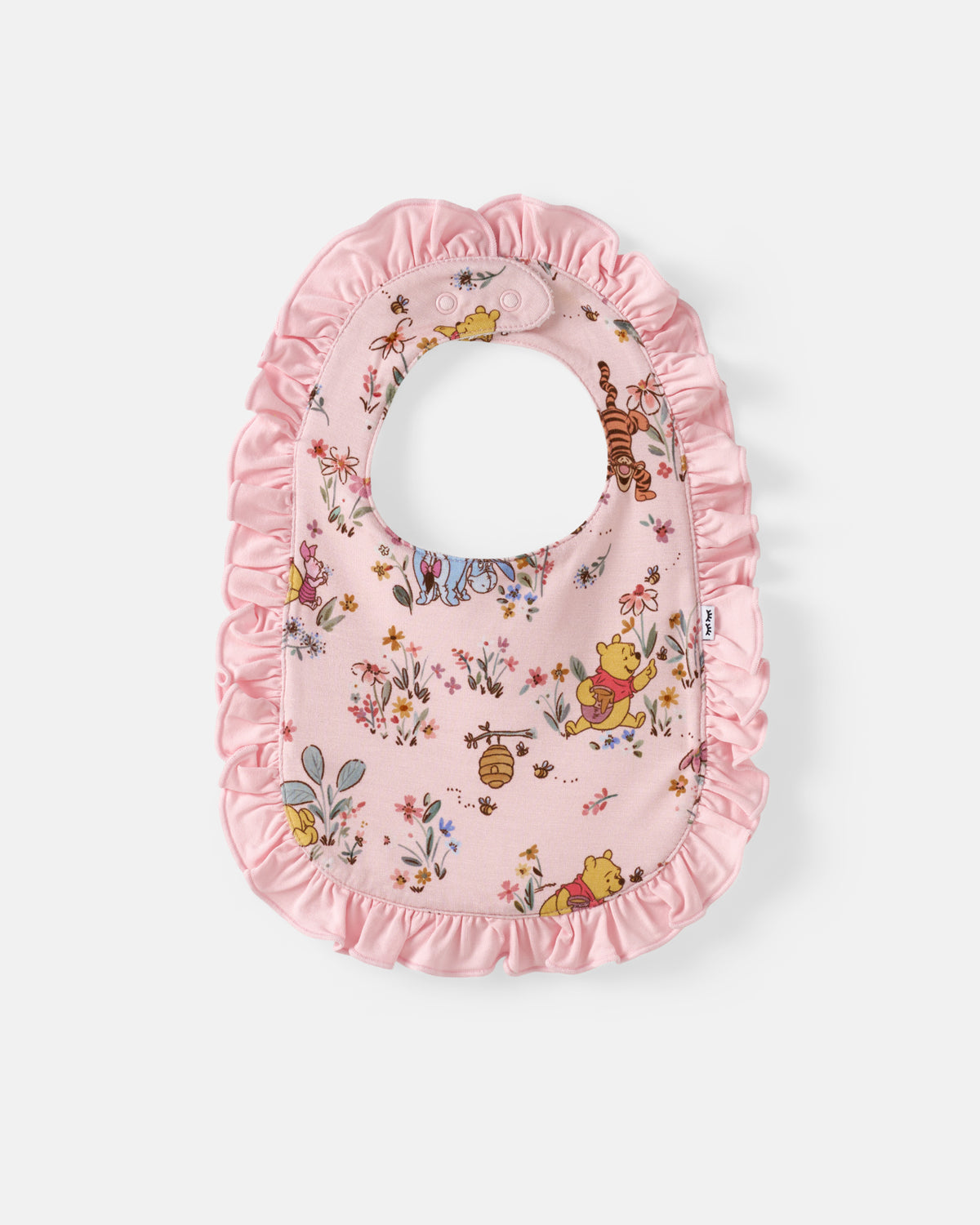 A pink baby bib with a ruffled trim, featuring a classic floral and animal print of Winnie the Pooh and Tigger on a light gray background.