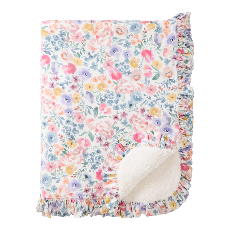 Floral patterned blanket with ruffled edge on a white background