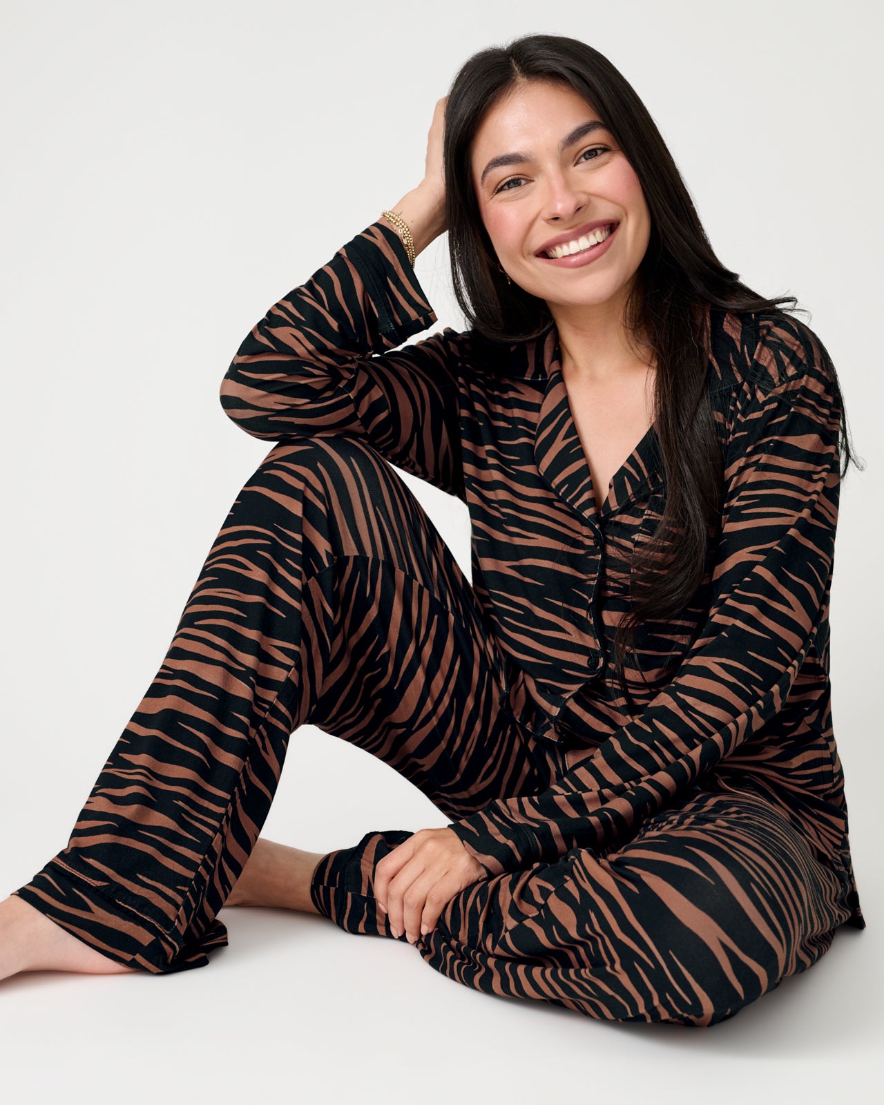 Sitting woman wearing the Wild Stripes Women's Long Sleeve Pajama Set