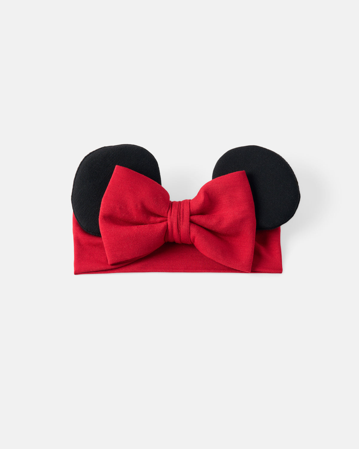 A red fabric headband with a large red bow and two black mouse-ear shapes on top, photographed on a plain light gray background.