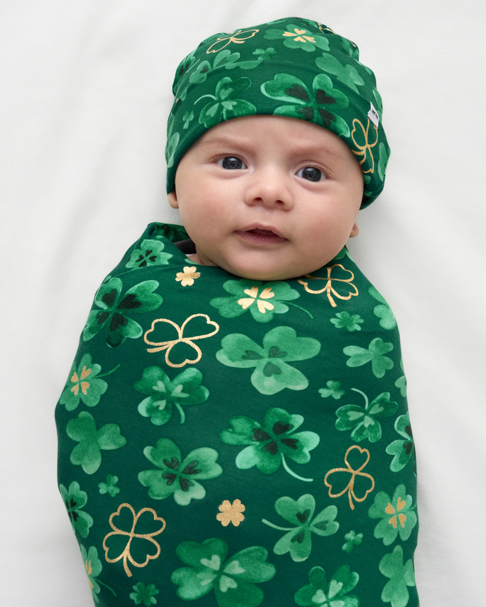 Close up of baby wrapped in the Clover Cuties Swaddle & Hat Set