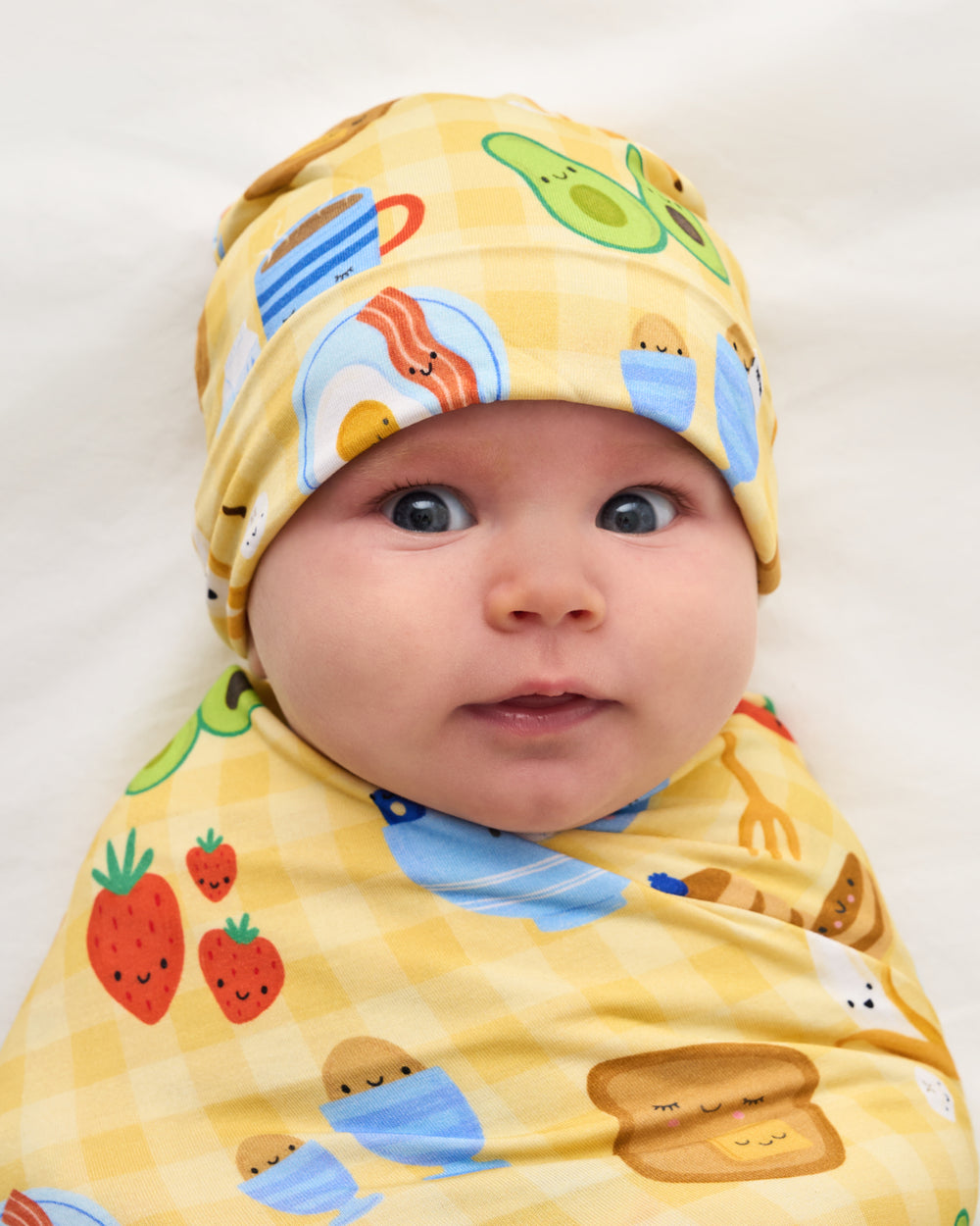 Close up of baby in the Breakfast Bunch Swaddle & Hat Set