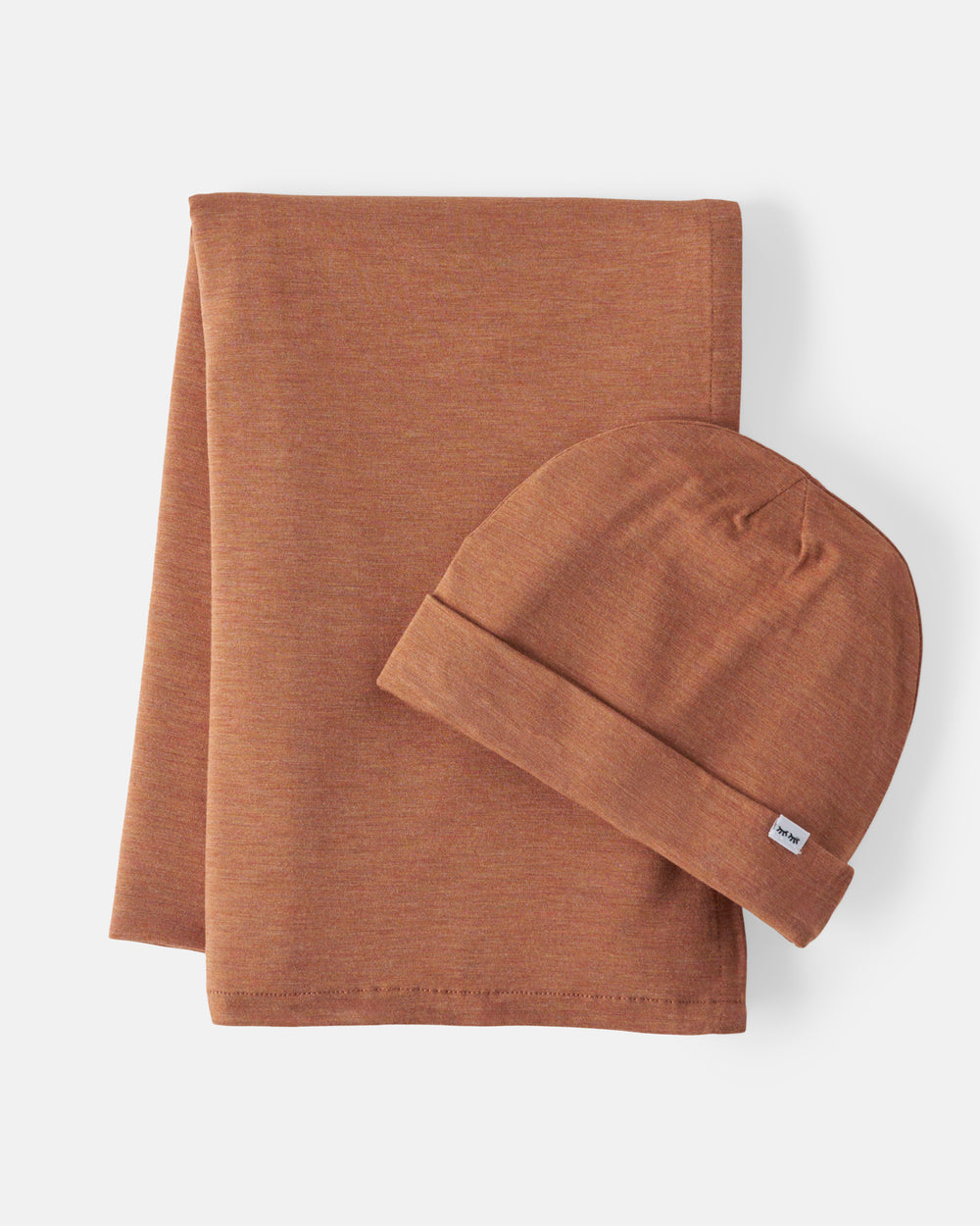 A terracotta-colored baby blanket and matching beanie set, neatly folded on a light gray background.