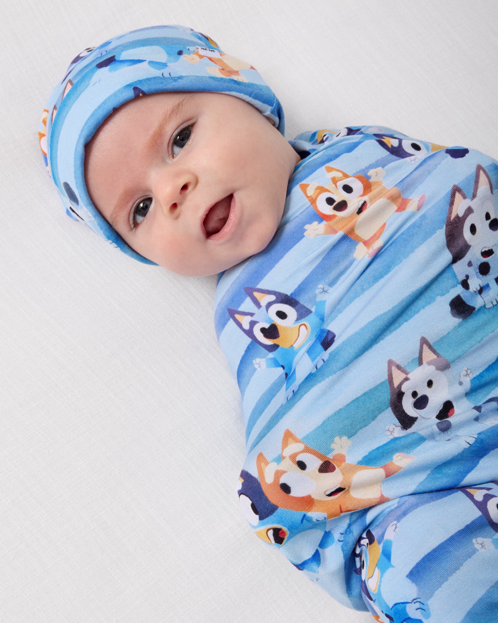 Close up of baby wearing the Bluey Dance All Day Swaddle & Hat Set