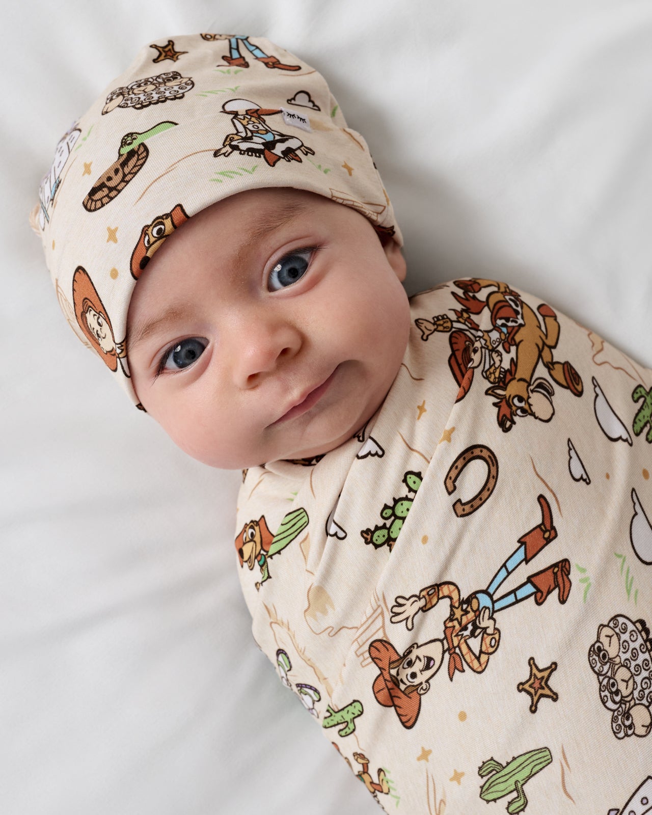 Close up of baby wrapped in the Disney & Pixar Woody's Wild West Swaddle & Beanie Set