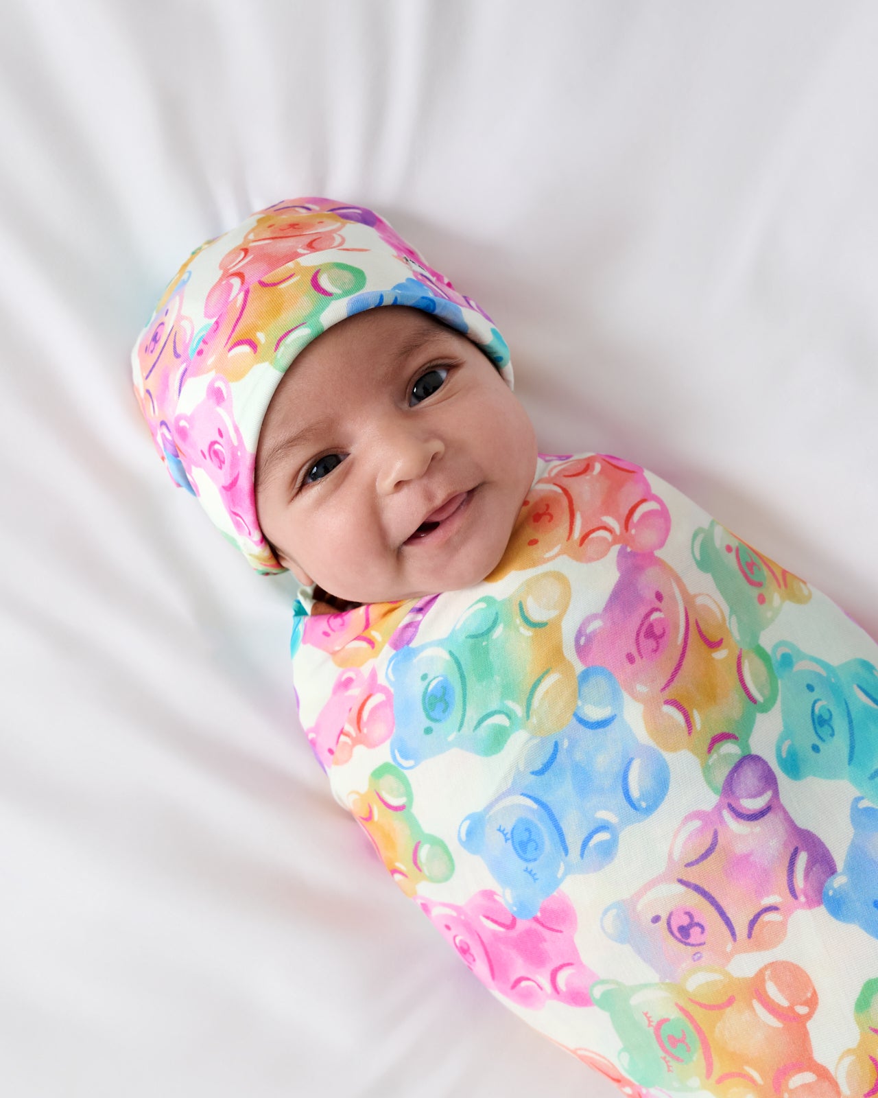 Close up newborn wrapped in the Gummy Giggles Swaddle & Beanie Set