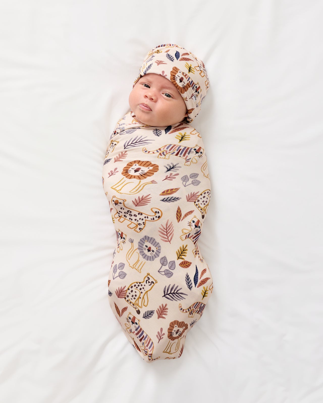 Aerial view of baby wrapped in the Savanna Friends Swaddle & Beanie Set