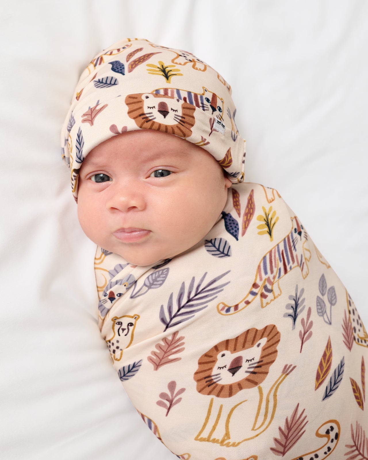 Close up of baby wearing the Savanna Friends Swaddle & Beanie Set