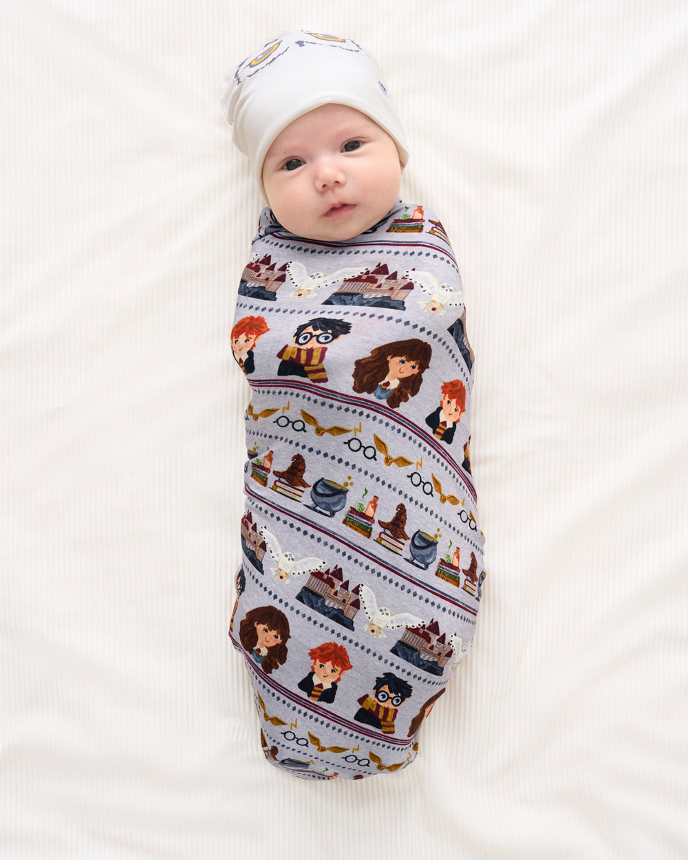 Aerial view of baby wrapped in the Harry Potter™ Spellbinding Studies Swaddle & Beanie Set