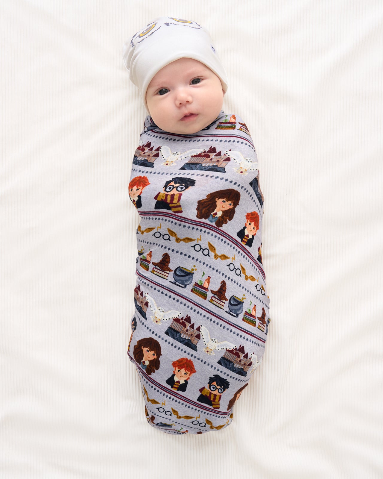 Aerial view of baby wrapped in the Harry Potter™ Spellbinding Studies Swaddle & Beanie Set
