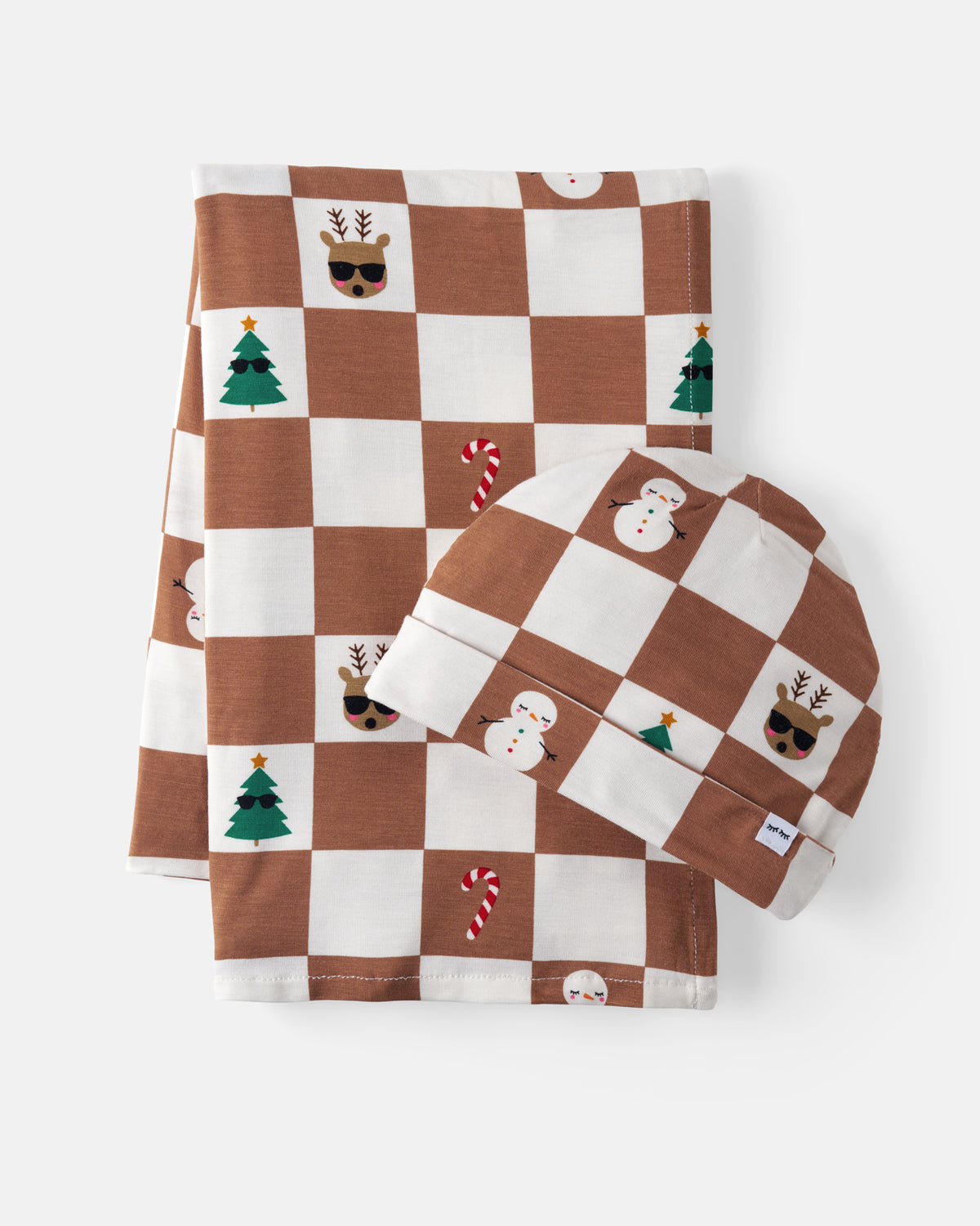 A matching baby blanket and beanie set with a brown and white checkered pattern decorated with Christmas motifs like trees and candy canes, shown on a light gray background.