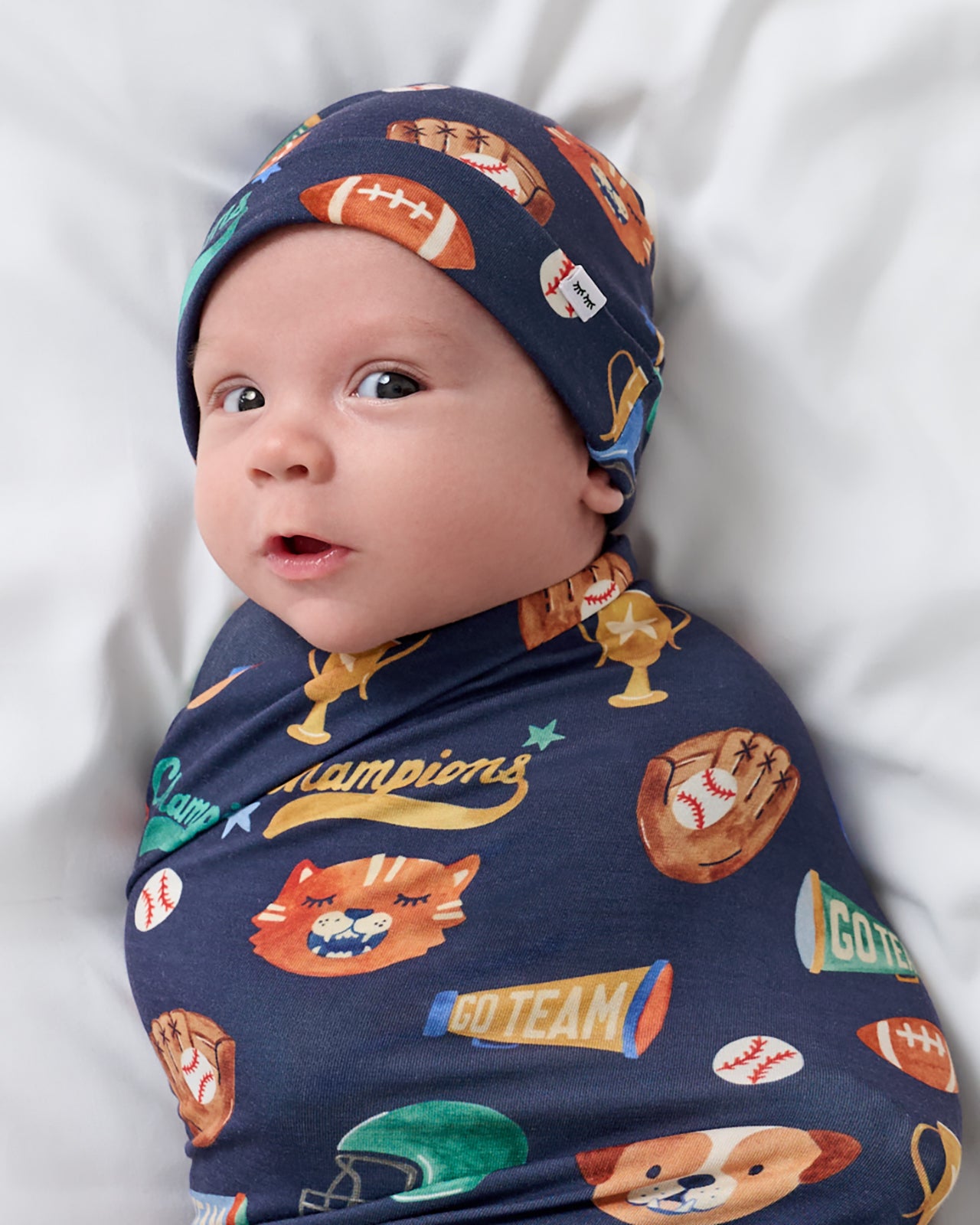 Close up of baby wrapped in the Team Spirit Swaddle & Beanie Set