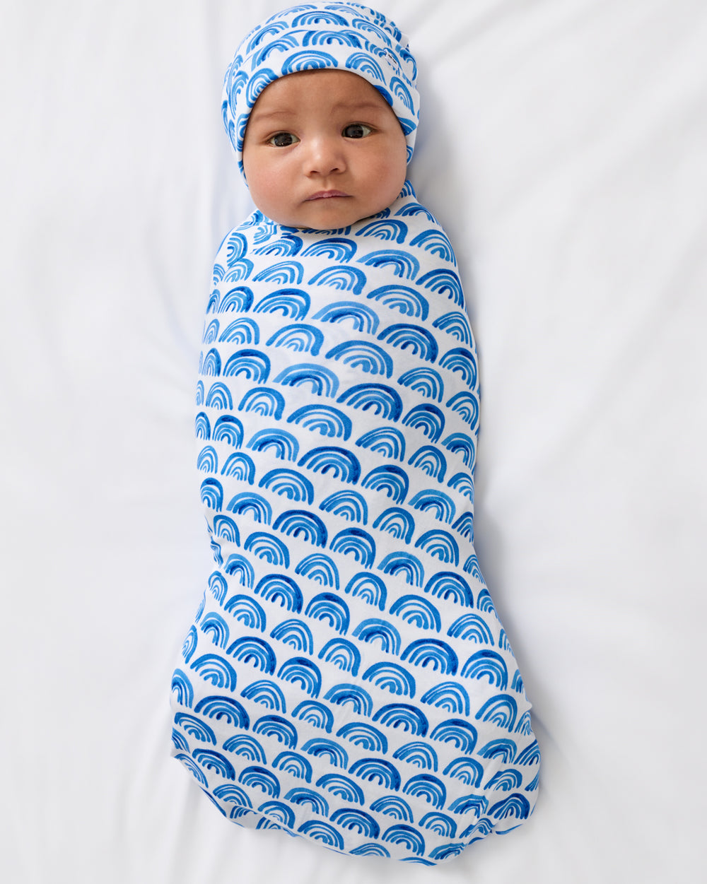 Aerial view of baby swaddled in the Blue Rainbows Swaddle & Beanie Set
