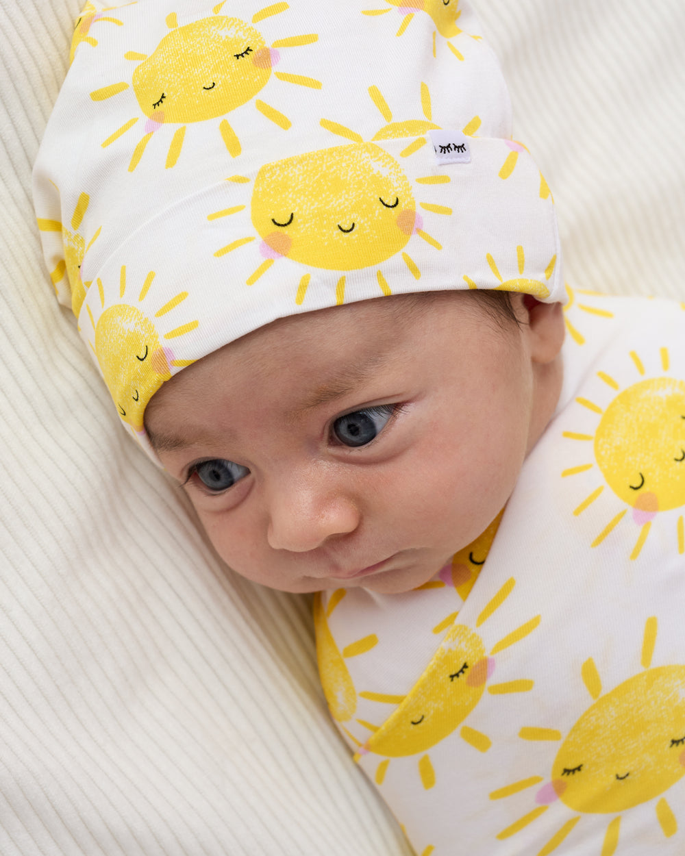 Close up of newborn wrapped in the Sunshine Swaddle & Beanie Set