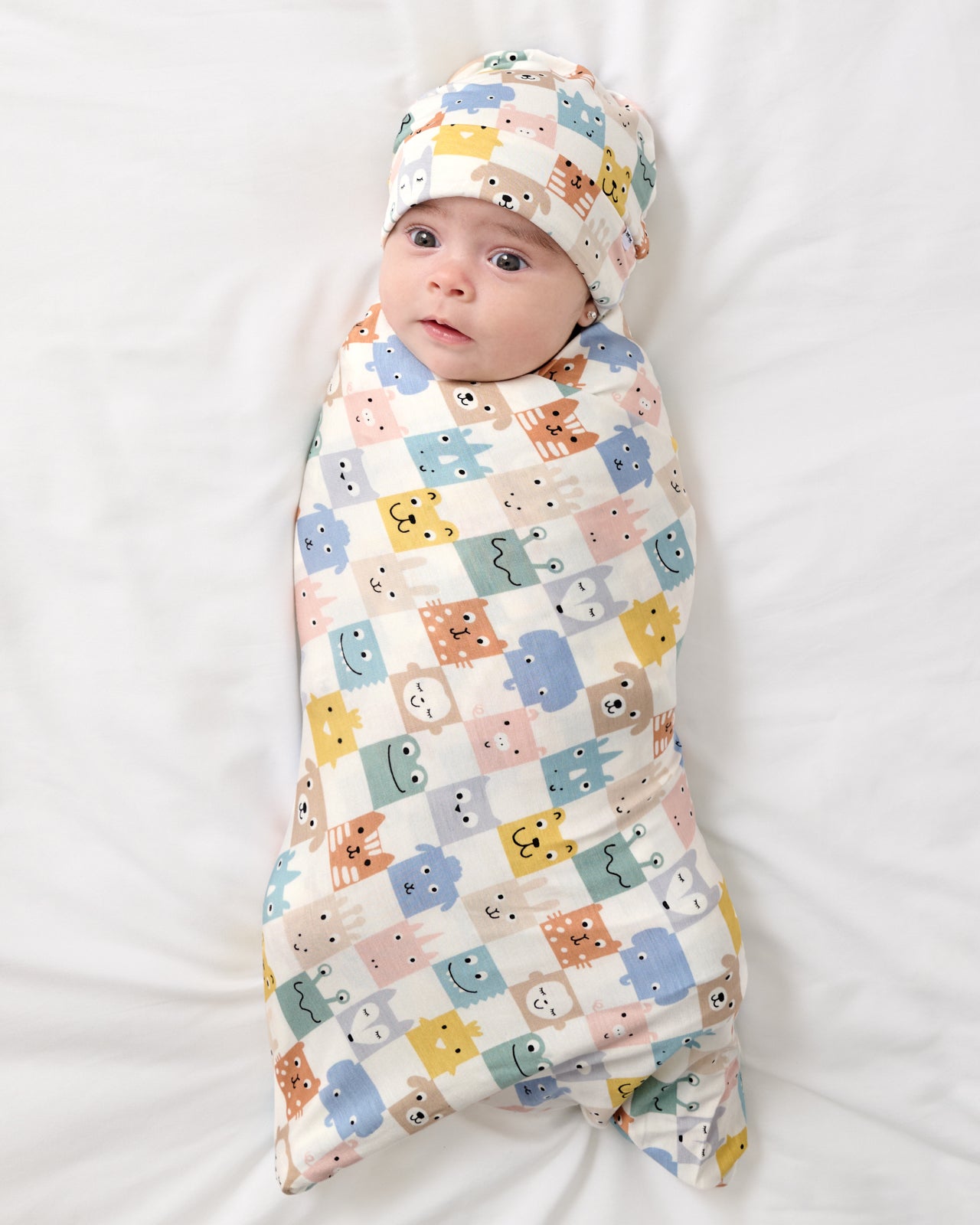 Aerial view of baby wearing the Check Mates Swaddle & Beanie Set