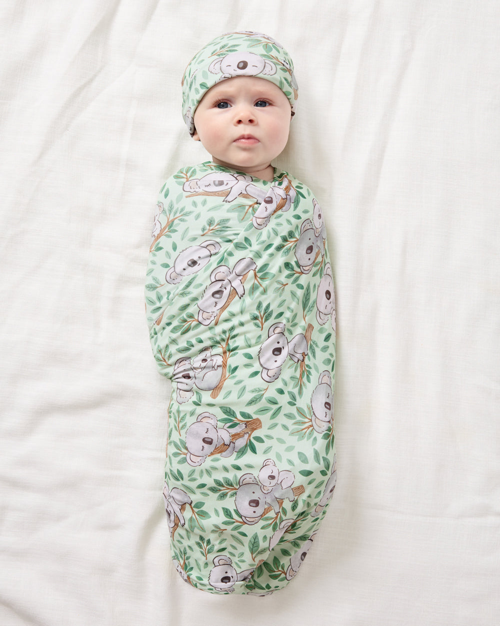 Aerial view of baby wearing the Koala Cuddles Swaddle & Beanie Set