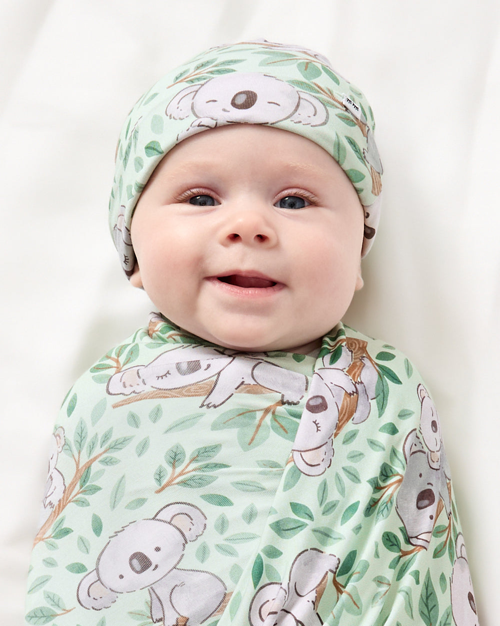 Close up of newborn wrapped in the Koala Cuddles Swaddle & Beanie Set