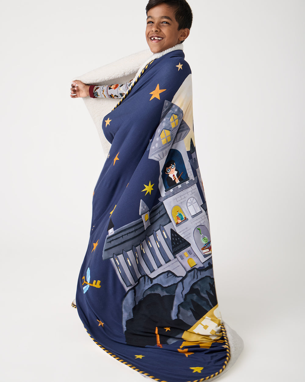 Boy wrapped in the Harry Potter™ Spellbinding Studies Sherpa Large Cloud Blanket®