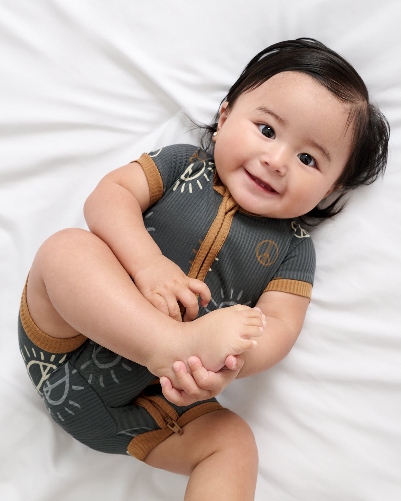 Aerial view of baby wearing the Peace & Love Ribbed Shorty Zippy