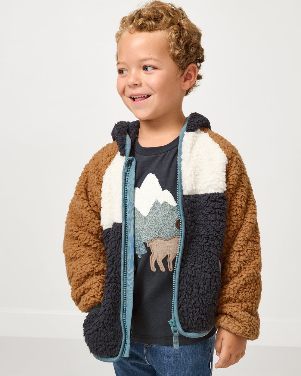 Boy wearing the Shadow Gray Sherpa Jacket layered over a graphic tee