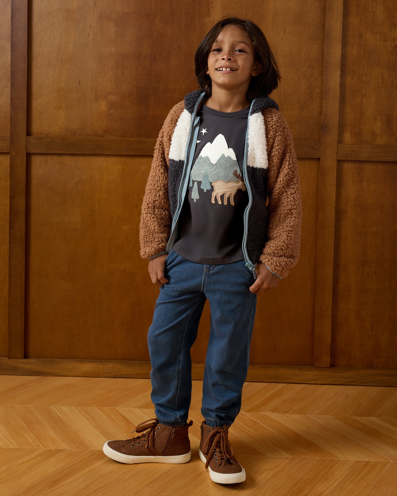 Boy wearing the Moose Trail Long Sleeve Relaxed Tee and Denim Joggers on a brown background