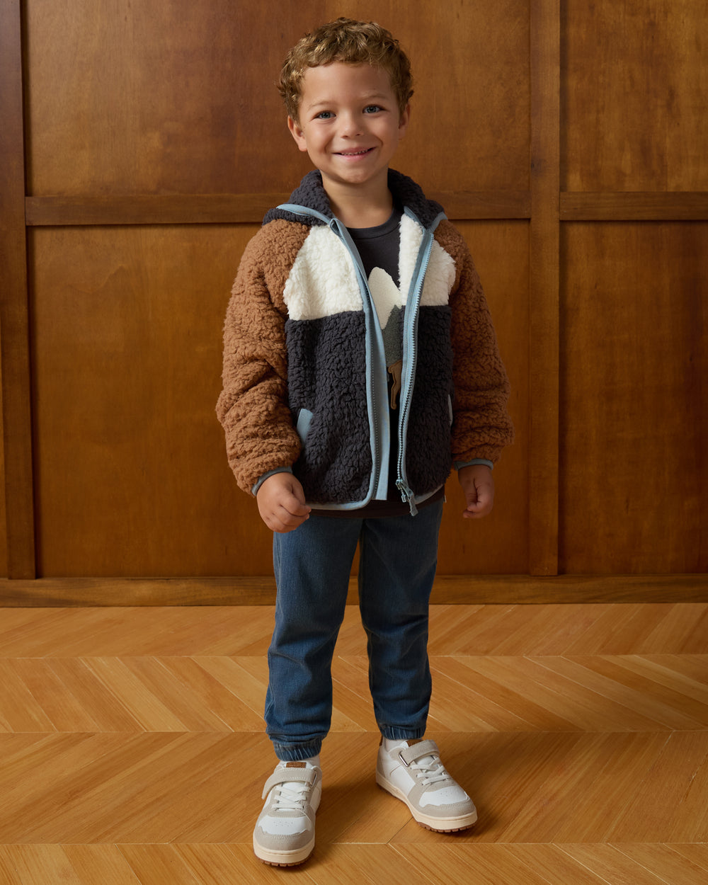 Child wearing the Shadow Gray Sherpa Jacket on a brown background