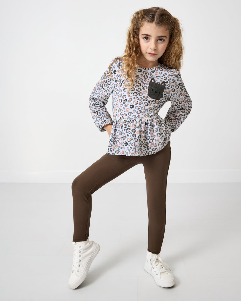 Girl wearing the Snowy Leopard Puff Sleeve Peplum Top with Mocha Leggings