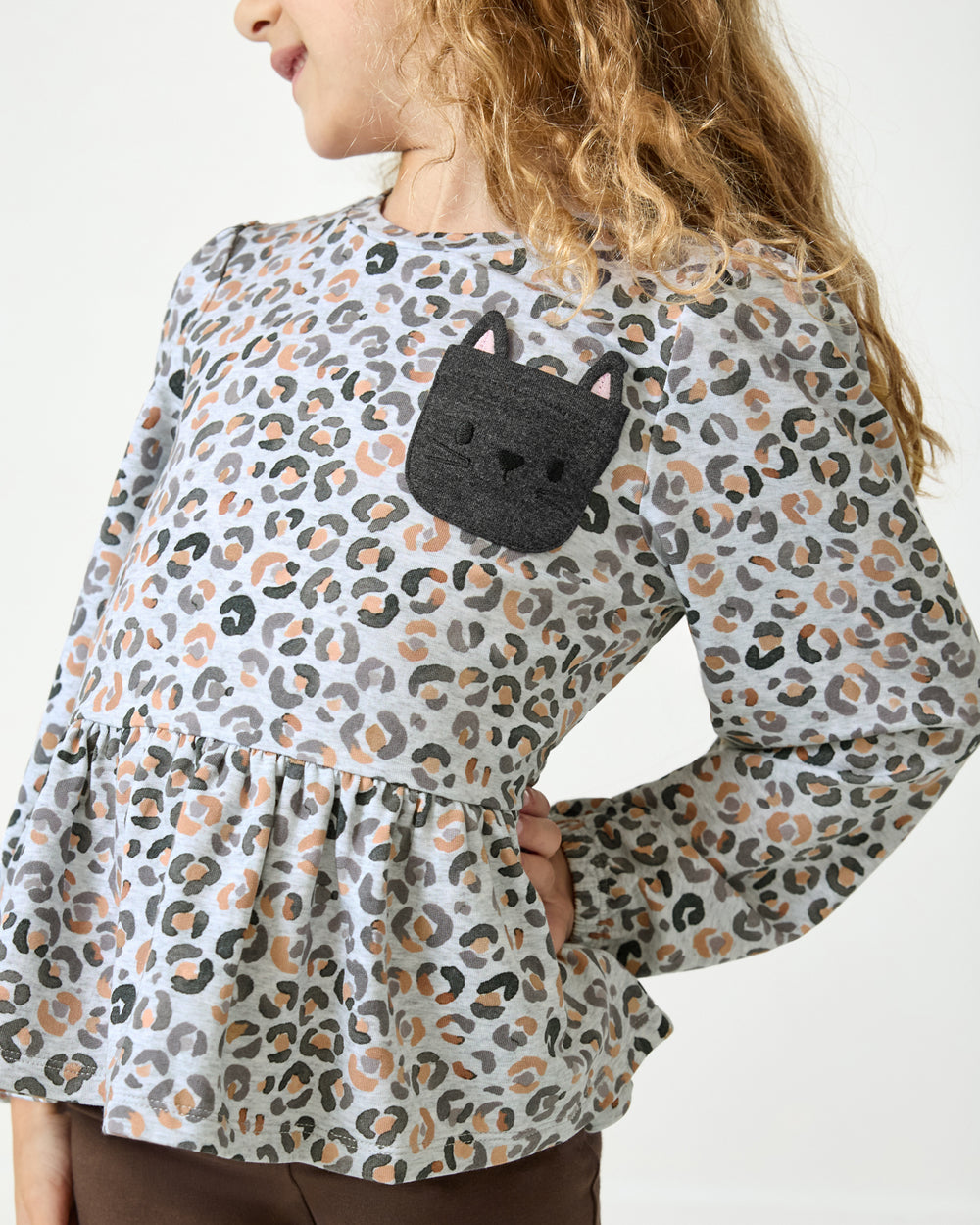 Close up of the pocket detail on the Snowy Leopard Puff Sleeve Peplum Top