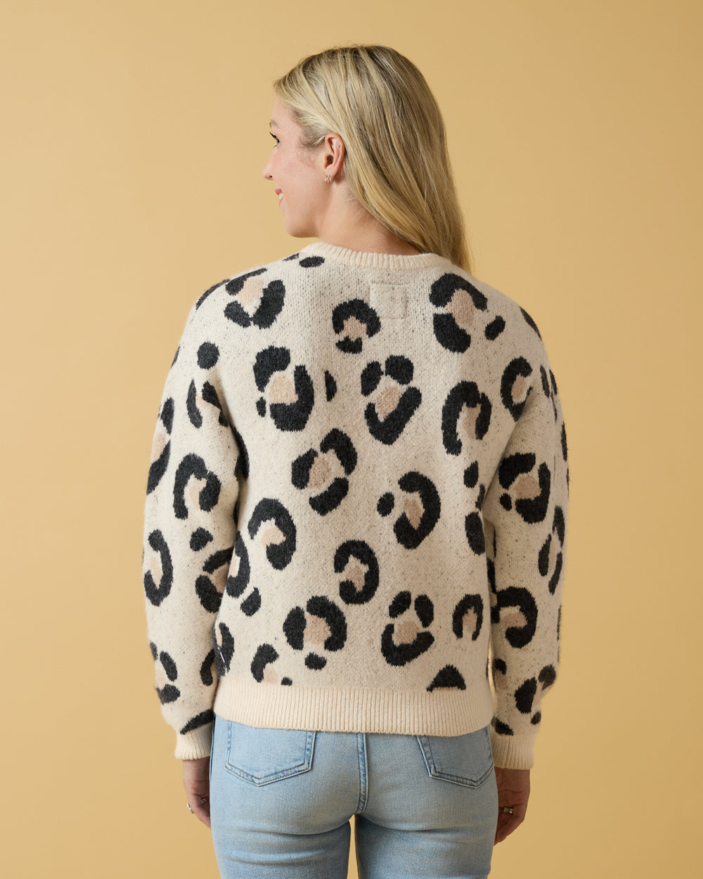 Back view of woman wearing the Snowy Leopard Women's Drop Shoulder Sweater