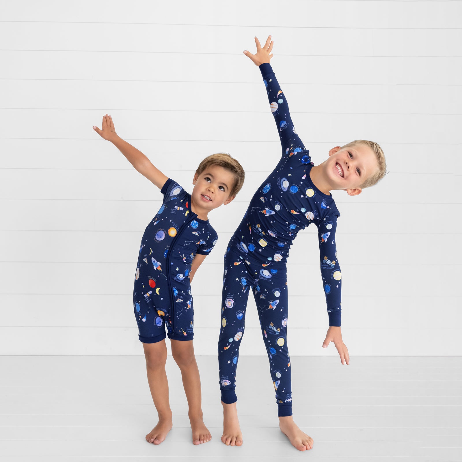 two children posing together wearing matching Through My Telescope pjs in shorty zippy and two piece styles