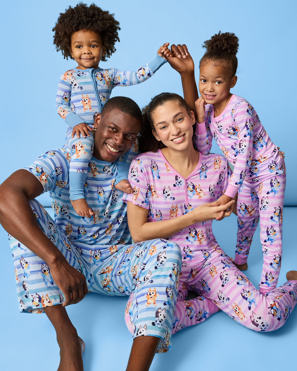 Family of four wearing the Bluey Dance All Day on a blue back drop