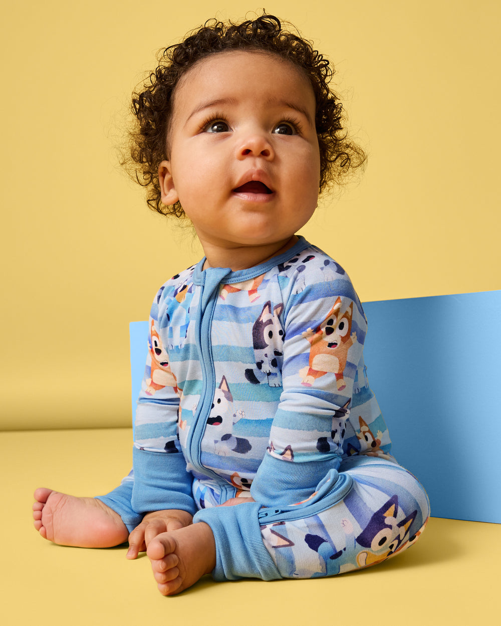 Sitting newborn wearing the Bluey Dance All Day Zippy