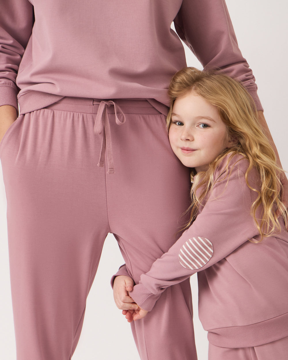 Girl wearing the Rosewood Crewneck Sweatshirt hugging her mother's leg