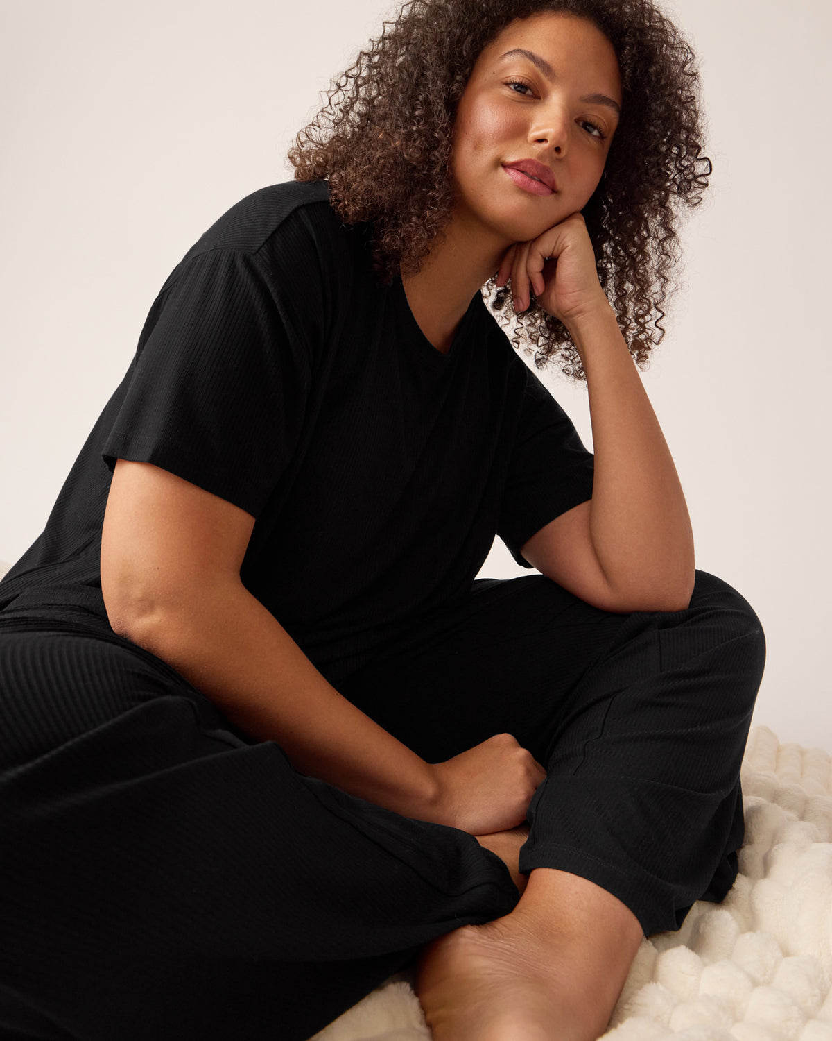 Sitting woman wearing the Black Women's Ribbed Boxy Tee